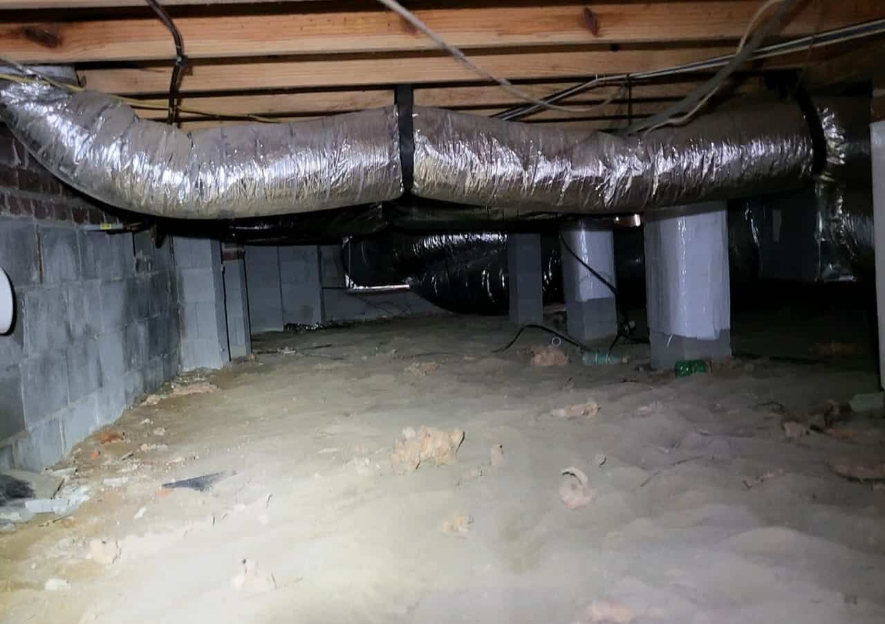 Before photo of Fayetteville, NC crawlspace with no vapor barrier and pieces of insulation on crawlspace floor.